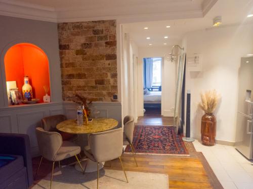 un salon avec une table et des chaises dans l'établissement Pic de Nôtre Dame, Charming Suites Paris, à Paris