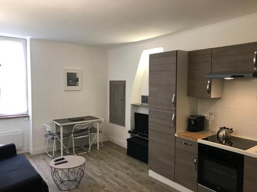 - un salon avec une cuisine et une table dans l'établissement Appartement climatisé Barjac centre ville, à Barjac