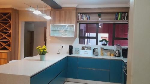 a kitchen with blue cabinets and a white counter top at Palma spaces in Pretoria