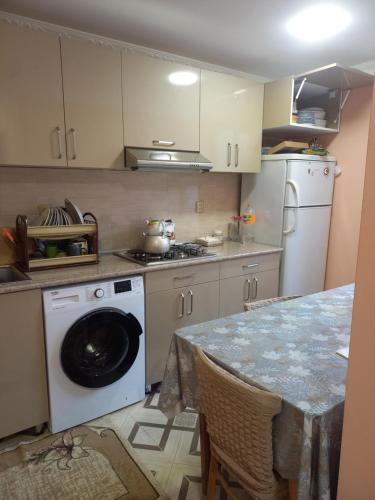 a kitchen with a washing machine and a table at Nicat in Quba