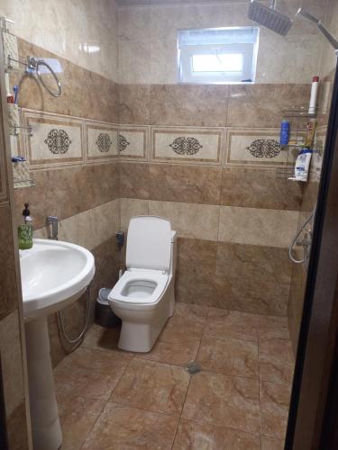 a bathroom with a toilet and a sink at Nicat in Quba