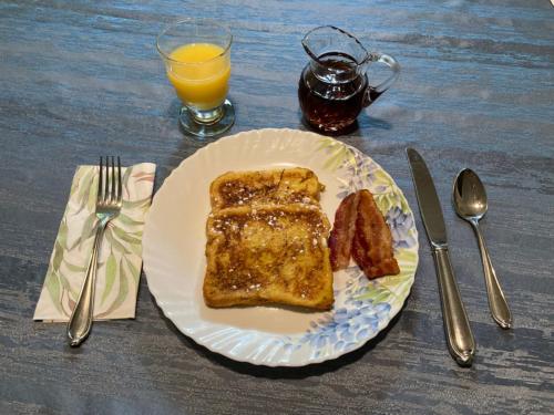 a plate of food with toast and a glass of orange juice at West Gate Bed and Breakfast in Gananoque
