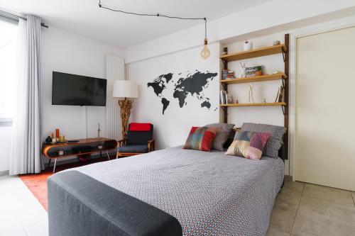 - une chambre avec un lit et une carte du monde sur le mur dans l'établissement Bright and Airy 1BD Apartment Quartier de la Gare, à Paris