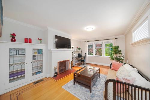 a living room with a couch and a tv at Charming Home Near UBC with Parking & Backyard in Vancouver