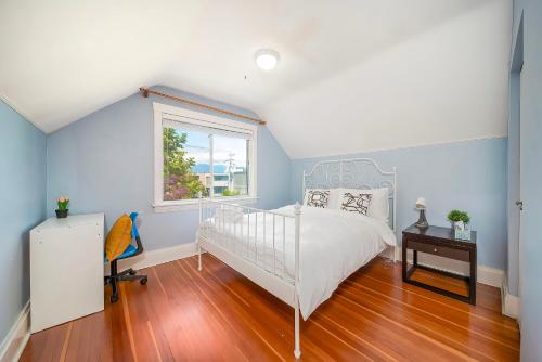 a bedroom with a white bed and a window at Charming Home Near UBC with Parking & Backyard in Vancouver