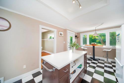 a kitchen with a black and white checkered floor at Charming Home Near UBC with Parking & Backyard in Vancouver