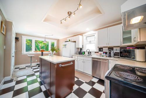 a kitchen with a black and white checkered floor at Charming Home Near UBC with Parking & Backyard in Vancouver
