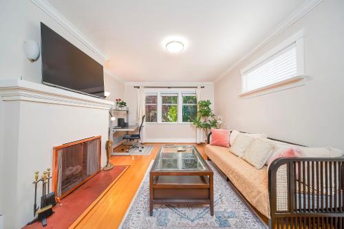 a living room with a couch and a fireplace at Charming Home Near UBC with Parking & Backyard in Vancouver
