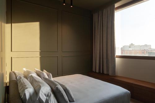 a bedroom with a bed with pillows and a window at Palazzo Giusti Lecce - Exclusive Boutique hotel in Lecce