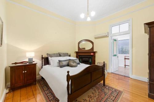 a bedroom with a bed and a table and a window at The Glen Iris 1913 in Toowoomba