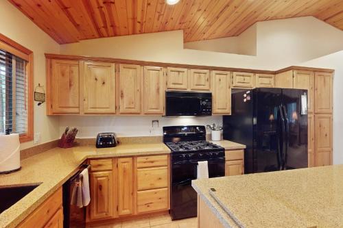 a kitchen with wooden cabinets and a black refrigerator at Par Paradise in Pinetop
