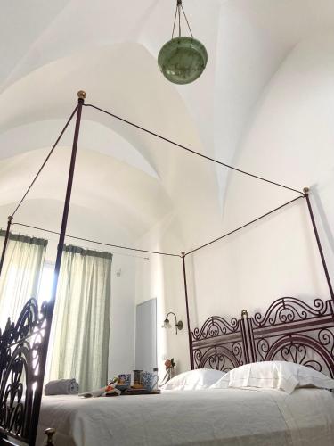 a bedroom with a bed with a metal canopy at Dimora Michelangelo in Alessano