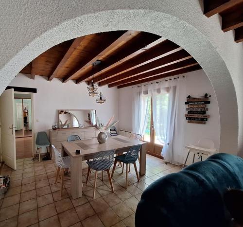 un salon avec une table et des chaises en bois dans l'établissement Maison à 20 min des plages Landaises, à Castets