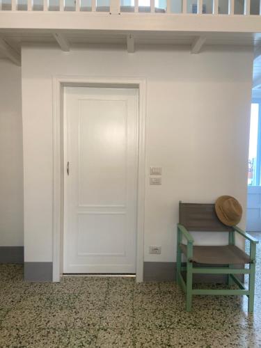 a white door and a bench in a room at Dimora Michelangelo in Alessano