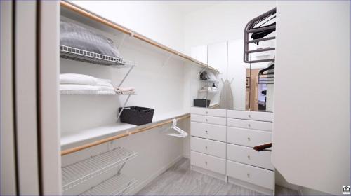 Un armario vacío con gabinetes blancos y estantes blancos. en Waterfront-amazing View W Fireworks-private-gated, en Scottsdale