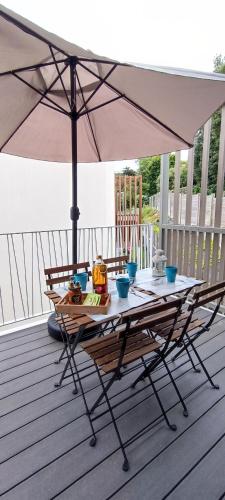 une table avec un parasol sur une terrasse dans l'établissement Les Hauts de Tanchet, à Château-dʼOlonne
