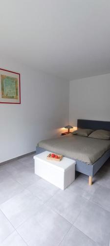 - une chambre avec un lit et une table blanche dans l'établissement Les Hauts de Tanchet, à Château-dʼOlonne