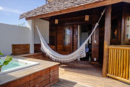 a hammock on a house with a hot tub at Hurricane Jeri in Jericoacoara