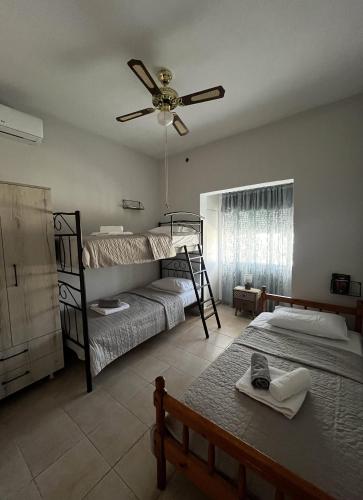 a bedroom with two bunk beds and a ceiling fan at Agnanti in AsfendhilÃ©s