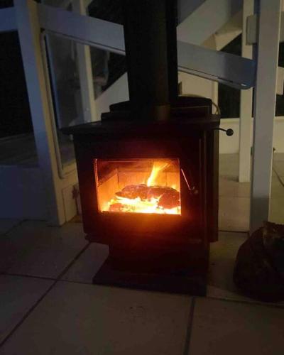 a stove that is open on a porch at Ludere Normanville in Normanville