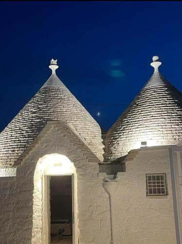 a building with two towers on top of it at Trulli Biancopumo - private pool in Monopoli