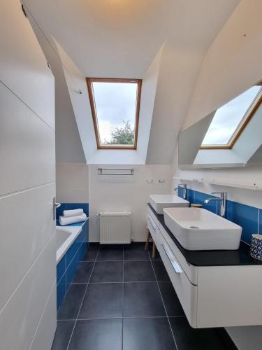 une salle de bain avec deux lavabos et une fenêtre dans l'établissement PHARE DE LUMIÈRE DE ST-LUNAIRE spacieux, à 5 min de la plage, à Saint-Lunaire