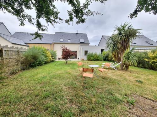un patio con sillas y una mesa en PHARE DE LUMIÈRE DE ST-LUNAIRE spacieux, à 5 min de la plage, en Saint-Lunaire