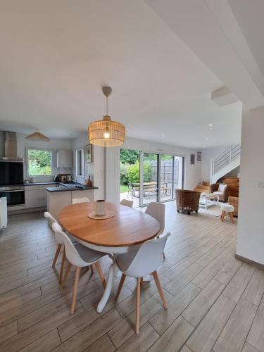 une cuisine et une salle à manger avec une table et des chaises en bois dans l'établissement PHARE DE LUMIÈRE DE ST-LUNAIRE spacieux, à 5 min de la plage, à Saint-Lunaire