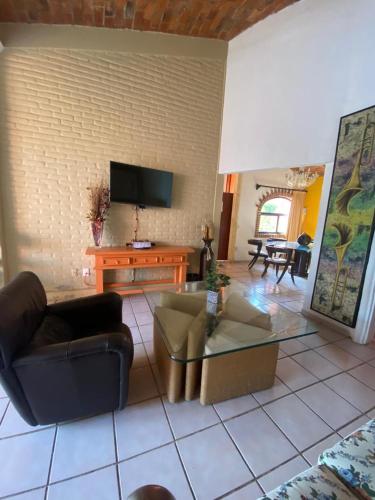 a living room with couches and a flat screen tv at Hotel Villas Ajijic, Ajijic Chapala Jalisco in Ajijic