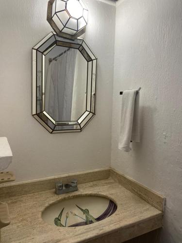 a bathroom with a sink with a mirror and a towel at Hotel Villas Ajijic, Ajijic Chapala Jalisco in Ajijic