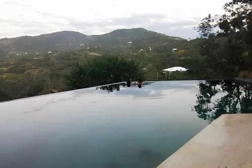 a swimming pool with mountains in the background at Descanso total en el mejor clima de Colombia in Anapoima