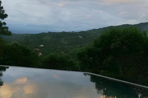 a pool of water with a view of a mountain at Descanso total en el mejor clima de Colombia in Anapoima