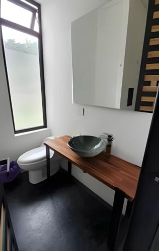 a bathroom with a wooden table with a bowl on it at Descanso total en el mejor clima de Colombia in Anapoima