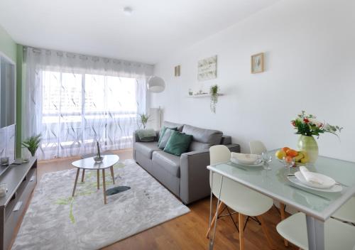 un salon avec un canapé et une table dans l'établissement Appartement cosy - Tonkin, parc Tête d'or, à Villeurbanne