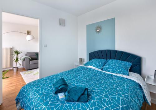 - une chambre avec un lit bleu et une couette bleue dans l'établissement Appartement cosy - Tonkin, parc Tête d'or, à Villeurbanne