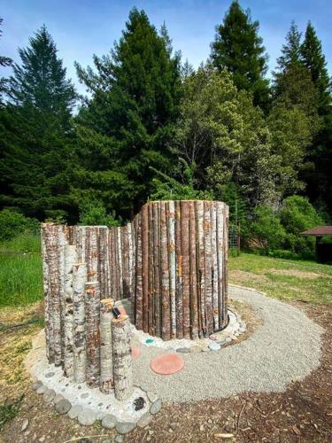 a structure made out of logs in a park at Little House in the Redwoods with a hot tub! in Garberville