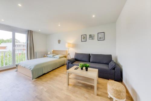 - une chambre avec un canapé, un lit et une table dans l'établissement Appartement Entier Proche la Défense & Paris & Hôpital de Colombes - Parking privé, à Colombes