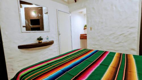 a bedroom with a colorful blanket on a bed at Hotel Casa de Arnold in Mazatlán