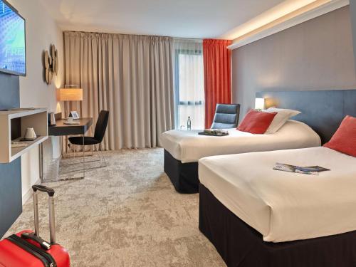 a hotel room with two beds and a desk at Best Western Plus Metz Technopole in Metz