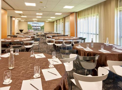 a conference room with tables and chairs andwindows at Best Western Plus Metz Technopole in Metz