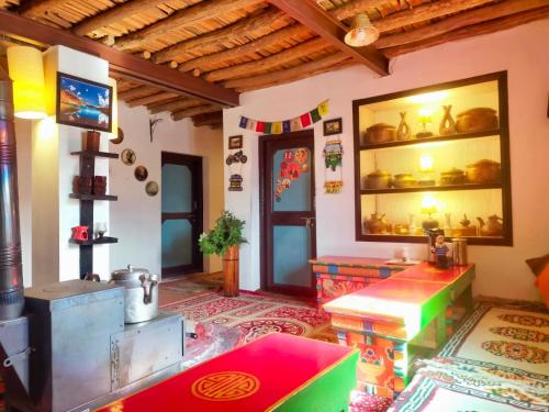 a living room with a table and a tv in it at The Nomad's Cottage-Losar , nearest hotel stay to visit Chandra Tal - Lake , in Spiti Valley in Losar
