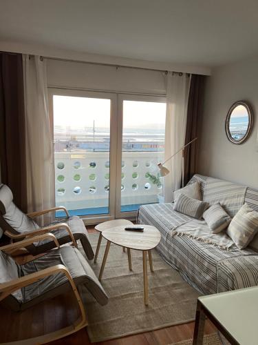 un salon avec un canapé et une grande fenêtre dans l'établissement L'Eau Vive 2 Front de mer 2e étage, à Le Touquet-Paris-Plage