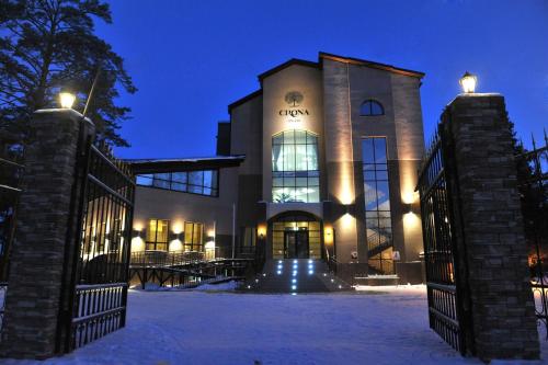 un edificio con una puerta en la nieve por la noche en Crona Hotel and SPA, en Berdsk