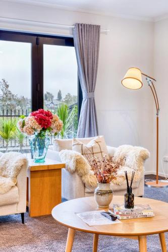 a living room with a couch and a table at Wonderful River View - Sunset Deck Retreat in Hamilton