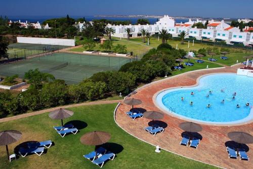 an overhead view of a pool with chairs and umbrellas at Prainha-Inn in Alvor