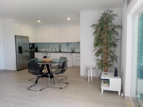 a kitchen with a glass table and a potted plant at Prainha-Inn in Alvor