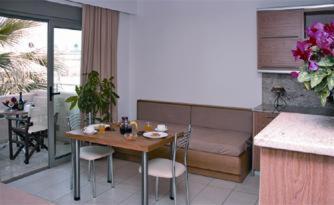 a living room with a table and a couch at Maria Apartments in Agia Pelagia