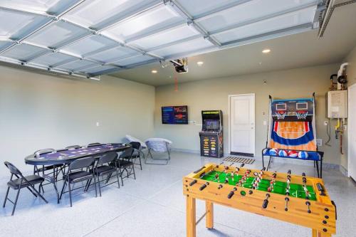 a room with a ping pong table and chairs at 7BR Pickleball Firepit Outdoor Kitchen Game Room in Coachella