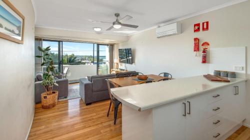 a kitchen and living room with a couch and a table at Baydream Believer - In the Heart of Husky with Free Linen in Huskisson