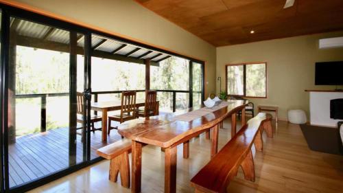 Una sala de estar con una mesa y sillas de madera. en Waterfront Hideway - Sanctuary Point - The Ultimate Spot to Relax, en Sanctuary Point